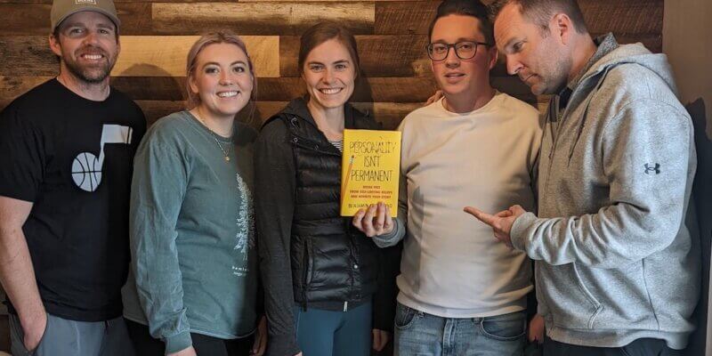 Lemonade Stand company book club - five members of the team hold the book Personality Isn't Permanent
